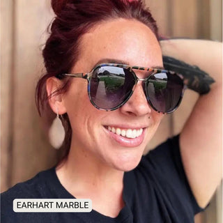 Woman wearing Earhart Marble aviator sunglasses featuring patterned tortoise frames with purple gradient lenses.