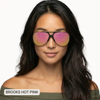 Woman wearing Brooks unisex large polarized aviator sunglasses with hot pink mirrored lenses and black frames.
