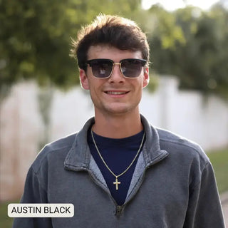 Young man wearing black gradient polarized square sunglasses with gold bridge, outdoors, casual style.