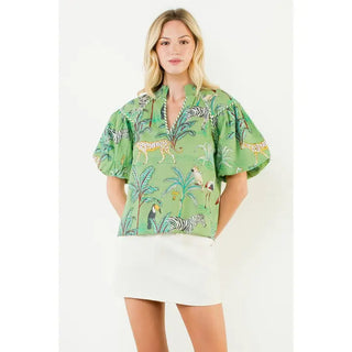 Green puff sleeve blouse featuring jungle animal print with zebras, cheetahs, toucans, and tropical palms.