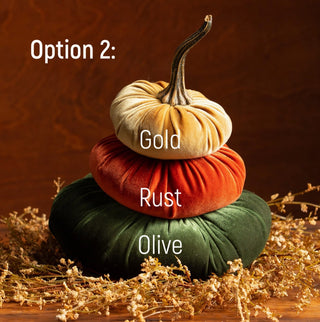 Three stacked velvet pumpkins in gold, rust, and olive green with a natural stem centerpiece.