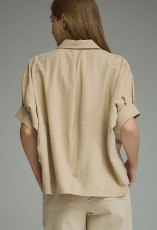 Beige linen-blend short sleeve button-front top with cuffed sleeves and relaxed dolman fit, back view.
