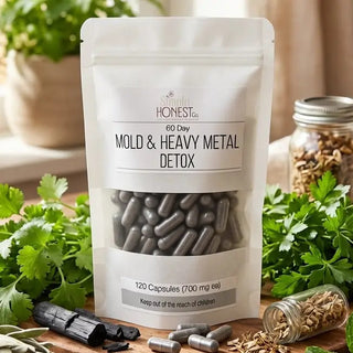 White pouch of Simply Honest Co. 60-Day Mold & Heavy Metal Detox, 120 gray capsules, surrounded by fresh herbs.