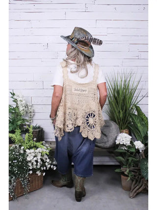 Relaxed-fit denim blue harem pants styled with lace vest and cowboy boots, back view.