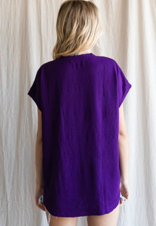Purple short cap sleeve solid top with raw edge hems, shown from the back view.