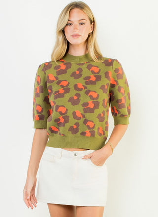 Short sleeve olive green leopard print knit sweater top with orange and brown spots, mock neck, puff sleeves.