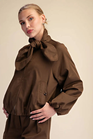 Brown scarf collar front zip puffy jacket with patch pocket, worn by blonde model.
