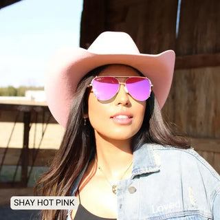 Woman wearing Shay hot pink mirrored polarized aviator sunglasses with pink cowboy hat and denim jacket.