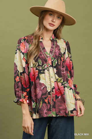 Black mix floral print button-front blouse with smocked bodice, puff sleeves, and lace trim detailing.