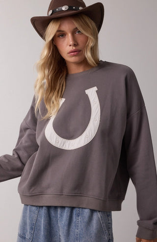 Charcoal gray French terry pullover sweatshirt with large white horseshoe appliqué, styled with cowboy hat and jeans.