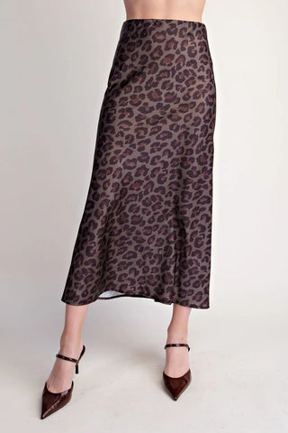 Brown and burgundy leopard print satin midi skirt with high waist, worn with dark brown pointed heels.