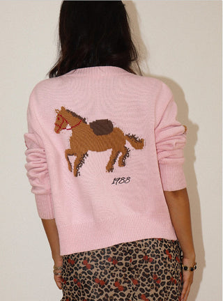 Pink knit cardigan with intarsia horse graphic and "1988" text on back, worn by model.
