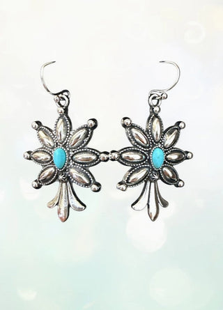 Silver squash blossom dangle earrings with turquoise center stones and detailed petal design on wire hooks.