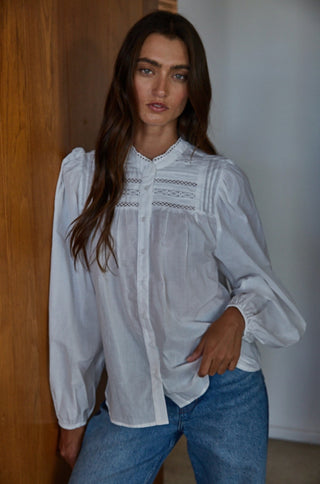 White woven cotton button-down blouse with lace trim detail, puffed long sleeves, and mandarin collar.