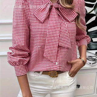 Red and white plaid long sleeve shirt with bow tie neckline, loose fit, button-front closure.