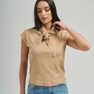 Beige knit sleeveless top with attached bow scarf neckline and white contrast trim detailing.