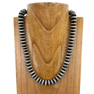 21-inch oxidized sterling silver Navajo pearl necklace with 15mm saucer-shaped beads displayed on wooden bust.