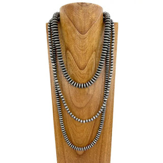 Three-layer oxidized silver Navajo pearl beaded necklace displayed on wooden jewelry bust, varying bead sizes.