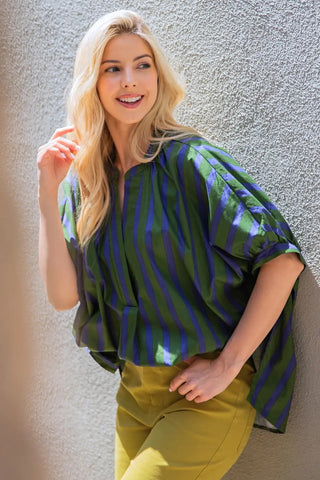 Oversized green and navy blue vertical stripe v-neck placket top with short puffed sleeves, worn casually.