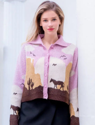 Lavender knit cardigan featuring Western desert scene with horses, cacti, and mountains, button-front closure.