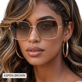 Women's oversized square sunglasses with gold metal frames and gradient brown lenses, tortoiseshell accents.