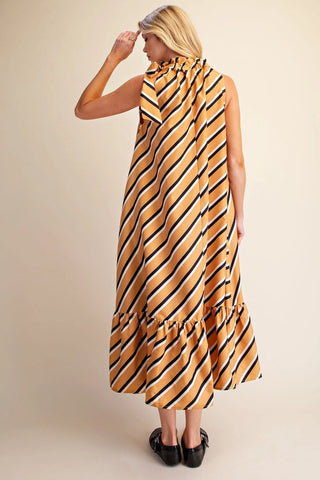 Mustard yellow diagonal striped sleeveless midi dress with ruffled neckline and hem, black loafers.
