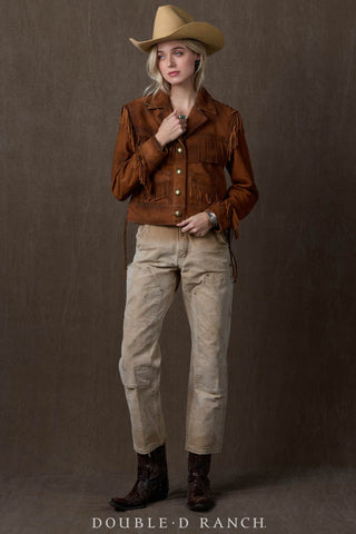 Brown suede fringe jacket with gold buttons, worn over beige distressed jeans and dark cowboy boots.