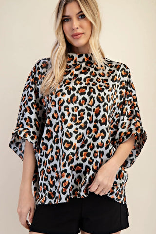 Oversized mock neck top in light gray leopard print with brown and black spots, three-quarter sleeves.