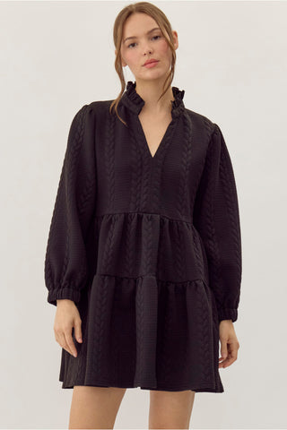 Black textured cable-knit tiered mini dress with ruffled V-neckline and long balloon sleeves.