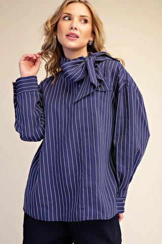 Navy blue pinstripe high neck shirt with bow tie detail and wide cuffs, long sleeves.