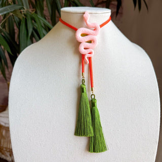 Blush pink coiled snake bolo necklace on solar orange cord with double olive green silk tassels.