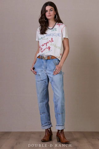 White graphic tee with colorful embroidered Western phrases, styled with light wash cargo jeans and brown cowboy boots.