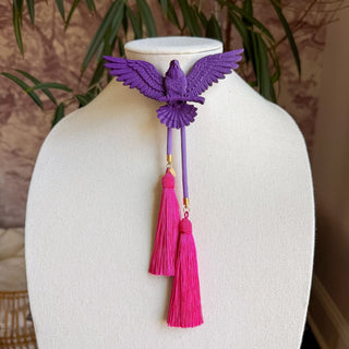 Purple 3D eagle bolo tie with lavender cords and vibrant fuchsia tassel pendants on display bust.
