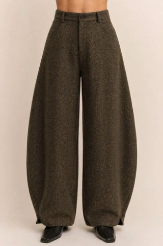 Olive brown herringbone high waist barrel leg wide pants with button closure and black boots.