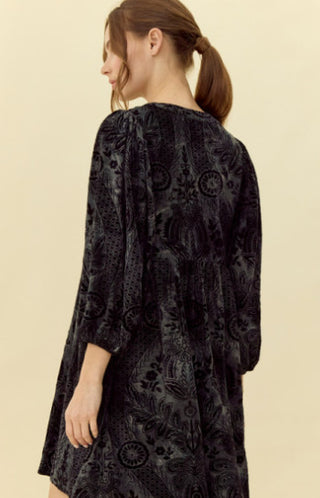 Velvet jacquard dress with round neckline and button placket, three quarter puffed sleeves, and side pockets.