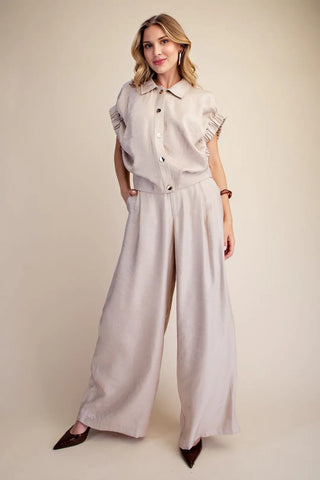 Light beige collared blouse with short ruffle elastic band sleeves and gold button front closure.