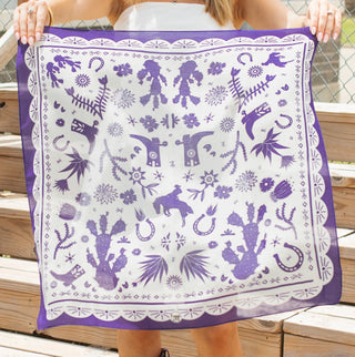 Purple and white bandana featuring Western motifs including cacti, horseshoes, longhorns, flowers, and cowgirl figures.
