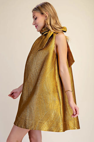 Gold metallic textured jacquard mini dress with ruffle tie neck detail, A-line silhouette, sleeveless.