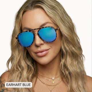 Woman wearing Earhart Blue aviator sunglasses with tortoise frames and vibrant blue mirrored polarized lenses.