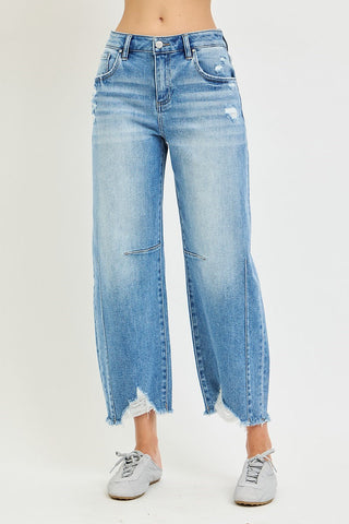 Light wash blue slouchy crop barrel jeans with distressed details and frayed raw hem edges.