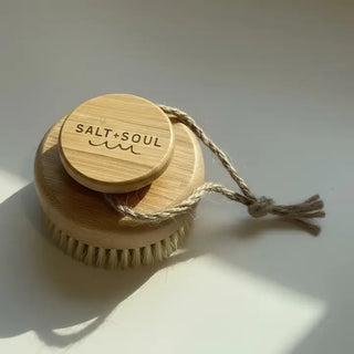 Circular bamboo dry body brush with natural bristles and jute rope loop, Salt+Soul branded lid.