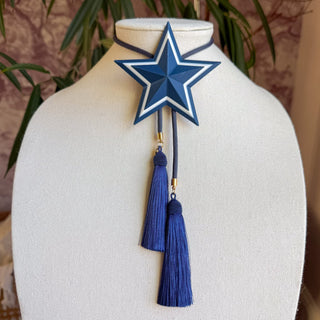 Blue and white striped star bolo tie necklace with navy tassels and gold cord tips on display bust.