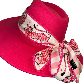 Pink heart leopard print Twilly scarf with pink rickrack trim tied around a hot pink wide-brim fedora hat.